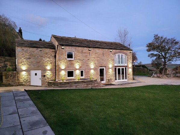 A stone house with a large front door, two windows, and a small balcony. - Green Barn (Sheffield)