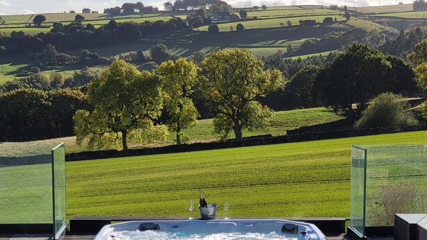 Un jacuzzi con vistas a colinas ondulantes y árboles.