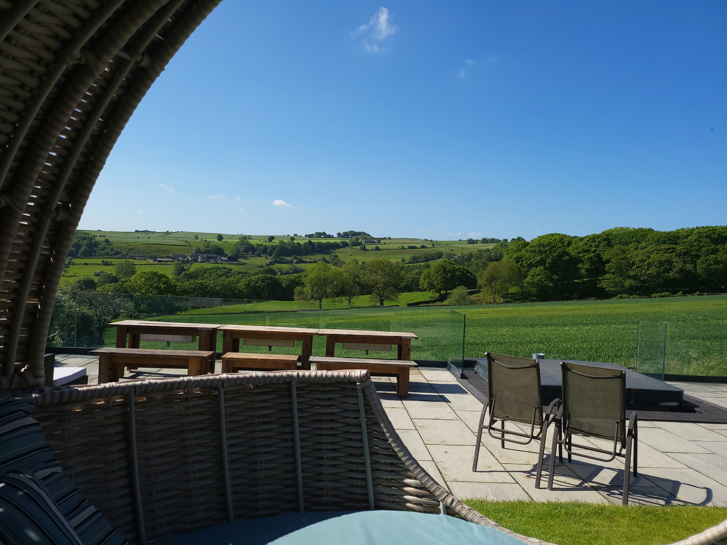 An outdoor patio with a view of rolling hills and a clear sky.