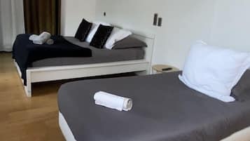 Habitación triple | Espacio para trabajar con laptop y ropa de cama