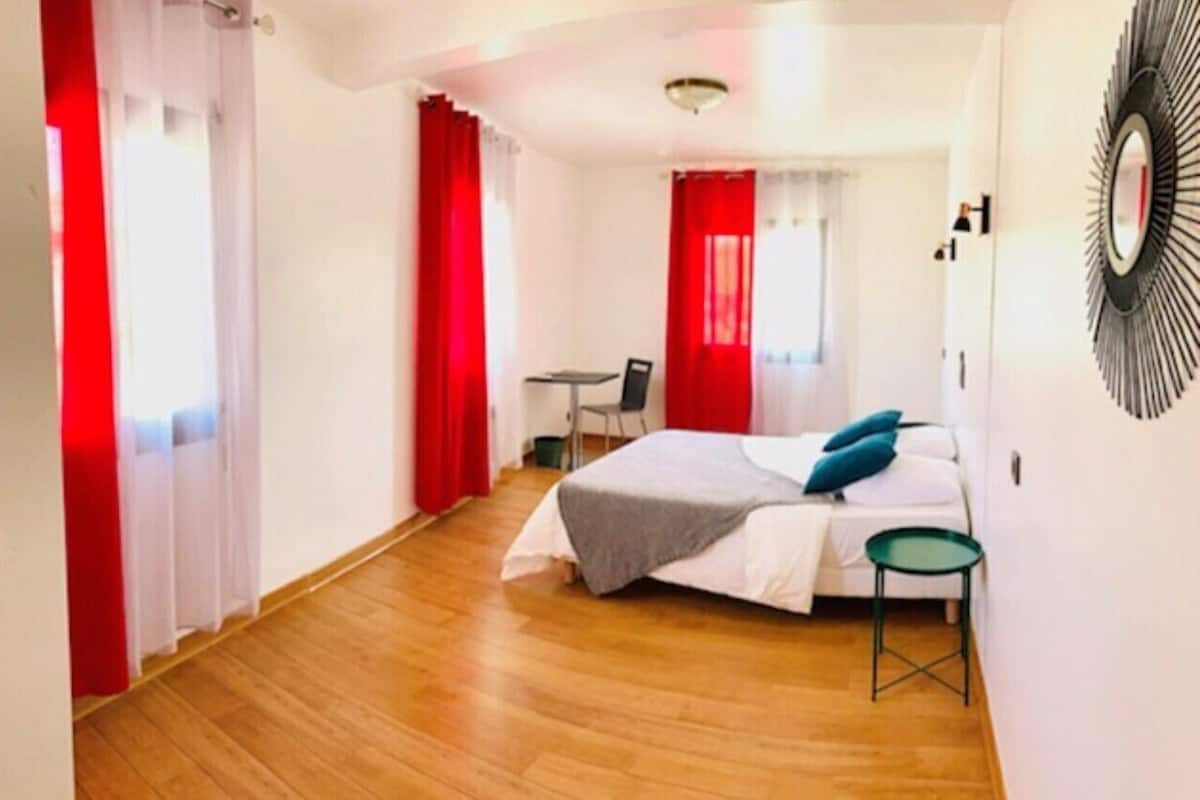 A bedroom with a bed, a desk, and a chair.