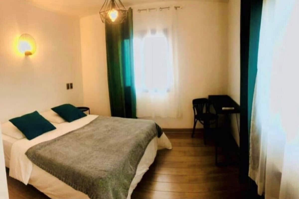 A room with a bed, a desk, and a chair.