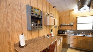 A kitchen with wooden cabinets, a granite countertop, and a window providing natural light. - Southern Comfort Cabin- minutes from the river and the lake! (Murfreesboro)
