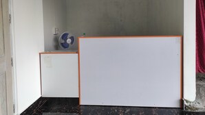 A room with a whiteboard, a fan, and a door. - Homecation Manas River Rock Lodge (Barnagar)