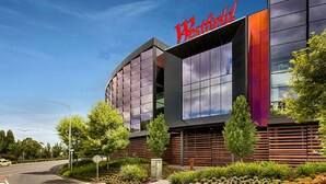 Un hotel moderno con un llamativo letrero de 'Westfield', que presenta una fachada curva y grandes ventanales.