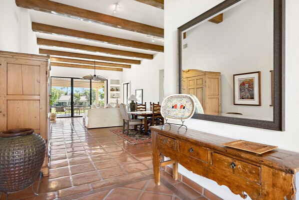 Um quarto amplo com um grande armário de madeira, um espelho e um chão em mosaico.