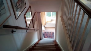 Una escalera con barandillas de madera y un rellano alfombrado.