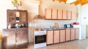 A kitchen with wooden cabinets, a stove, a sink, and a refrigerator. - Holiday Home "Balis Panorama" with Sea View, Balcony, Garden & Wi-Fi (Corfu)