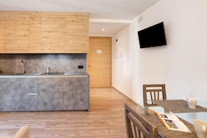Une cuisine moderne avec des meubles en bois, un plan de travail gris et une cuisinière intégrée.