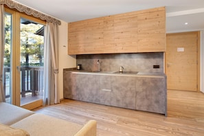 A modern kitchen with wooden cabinets, a grey countertop, and a sliding glass door leading to an outdoor area.