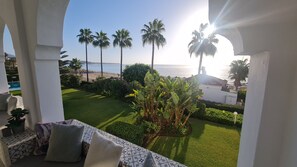 A balcony with a view of the sea, palm trees, and a well-maintained lawn. - Apartment "240 Front Line Beach La Cala" with Wi-Fi (la cala de mijas)