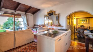 Una cocina compacta con un lavamanos, una zona de comedor con sillas, un sofá y vistas al exterior.