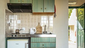 Una cocina compacta con refrigerador, estufa y armarios.