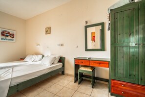Un dormitorio con cama, escritorio, silla y armario.