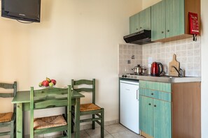 Une cuisine équipée d’une table à manger, de chaises, d’un réfrigérateur et d’un four à micro-ondes.