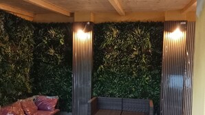 An indoor seating area with a sofa, a small table, and a wall with vertical panels. - Holiday Home 'Apt in Serra' with Private Pool, Wi-Fi & Air Conditioning (Quartu Sant'Elena)