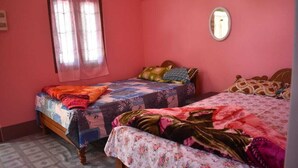 A bedroom with two beds, a window with curtains, and a mirror on the wall. - Homocation Ray Homestay (Barnagar)