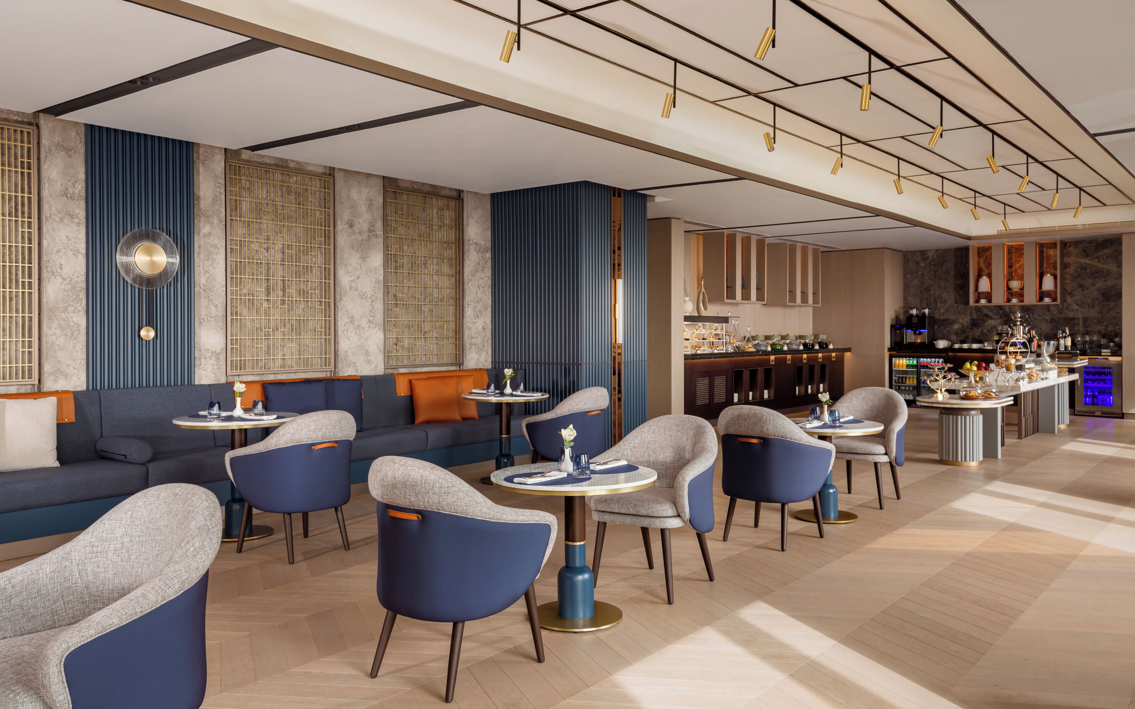 A modern interior with a bar area, seating arrangements, and a decorative ceiling.