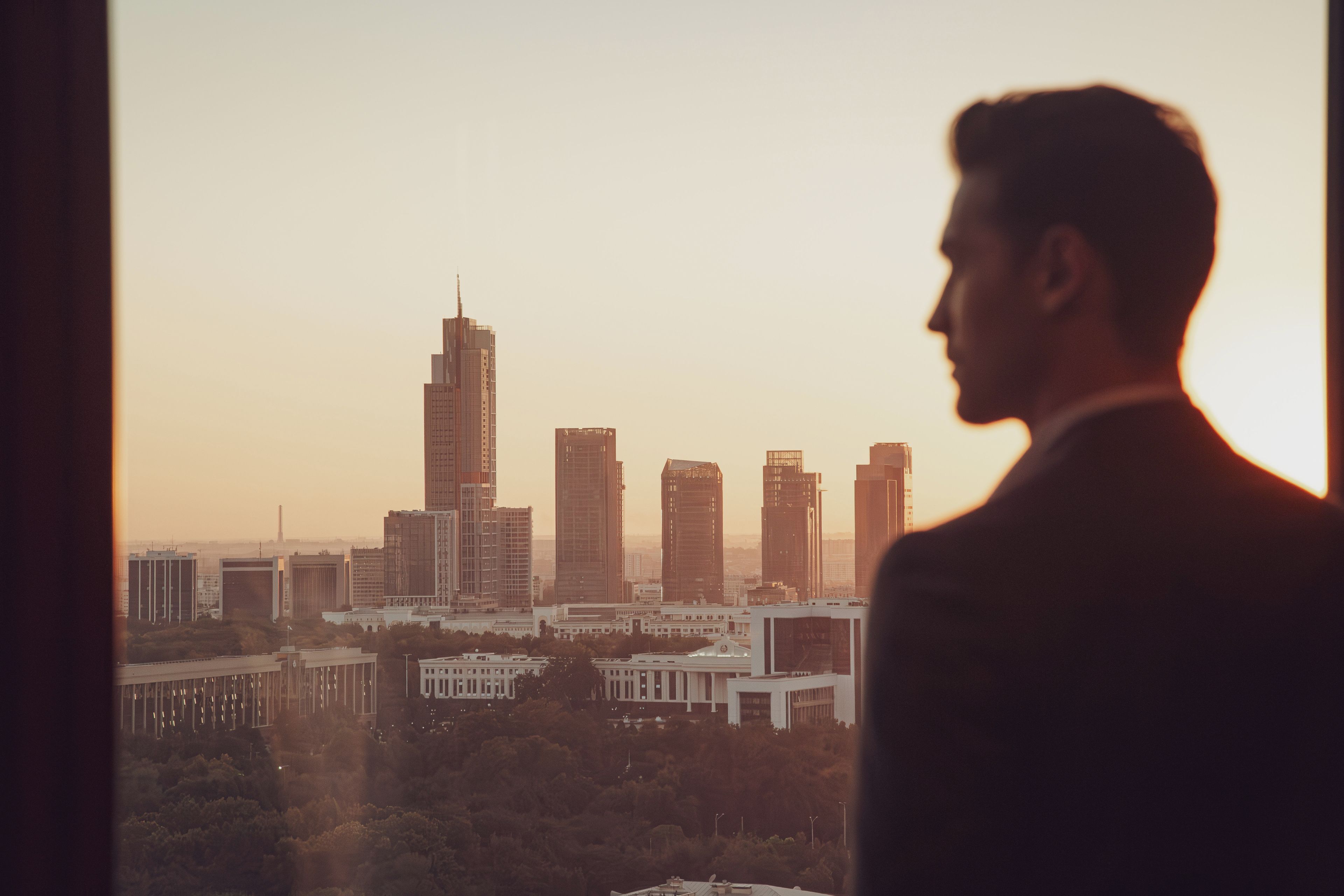 A cityscape with modern high-rise buildings and a person in a suit.