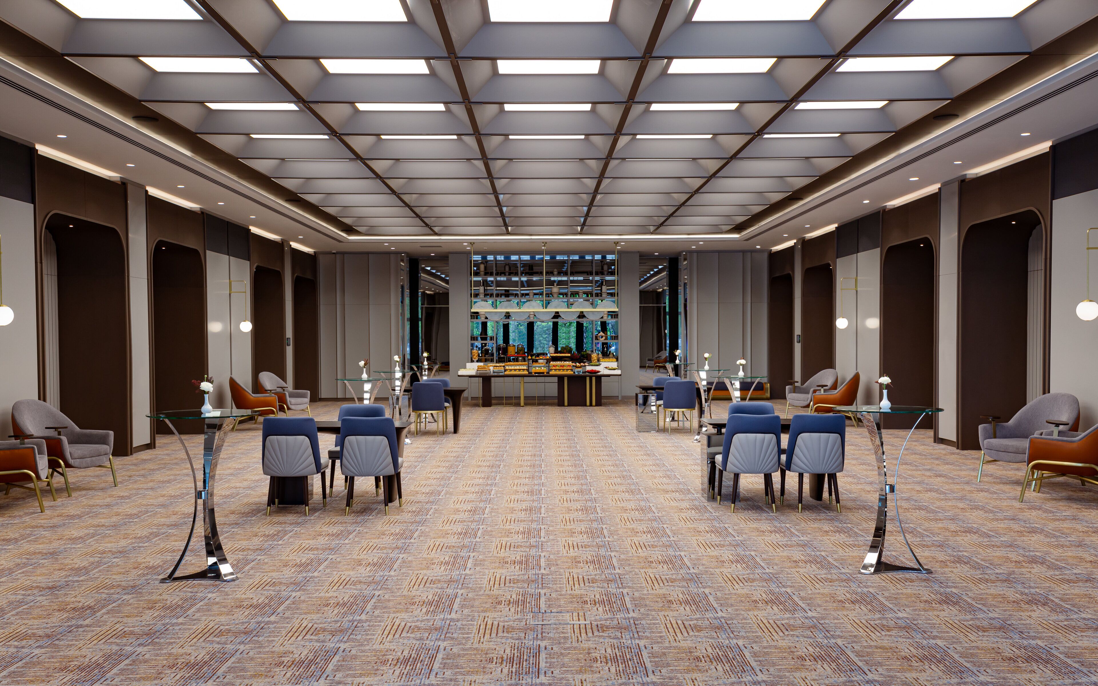 A spacious conference room with a patterned carpet, modern chairs, and a central buffet table.