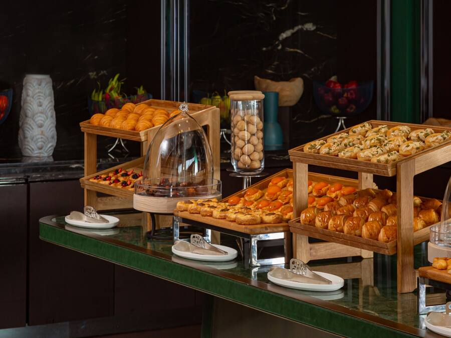 A buffet with various pastries and fruits.