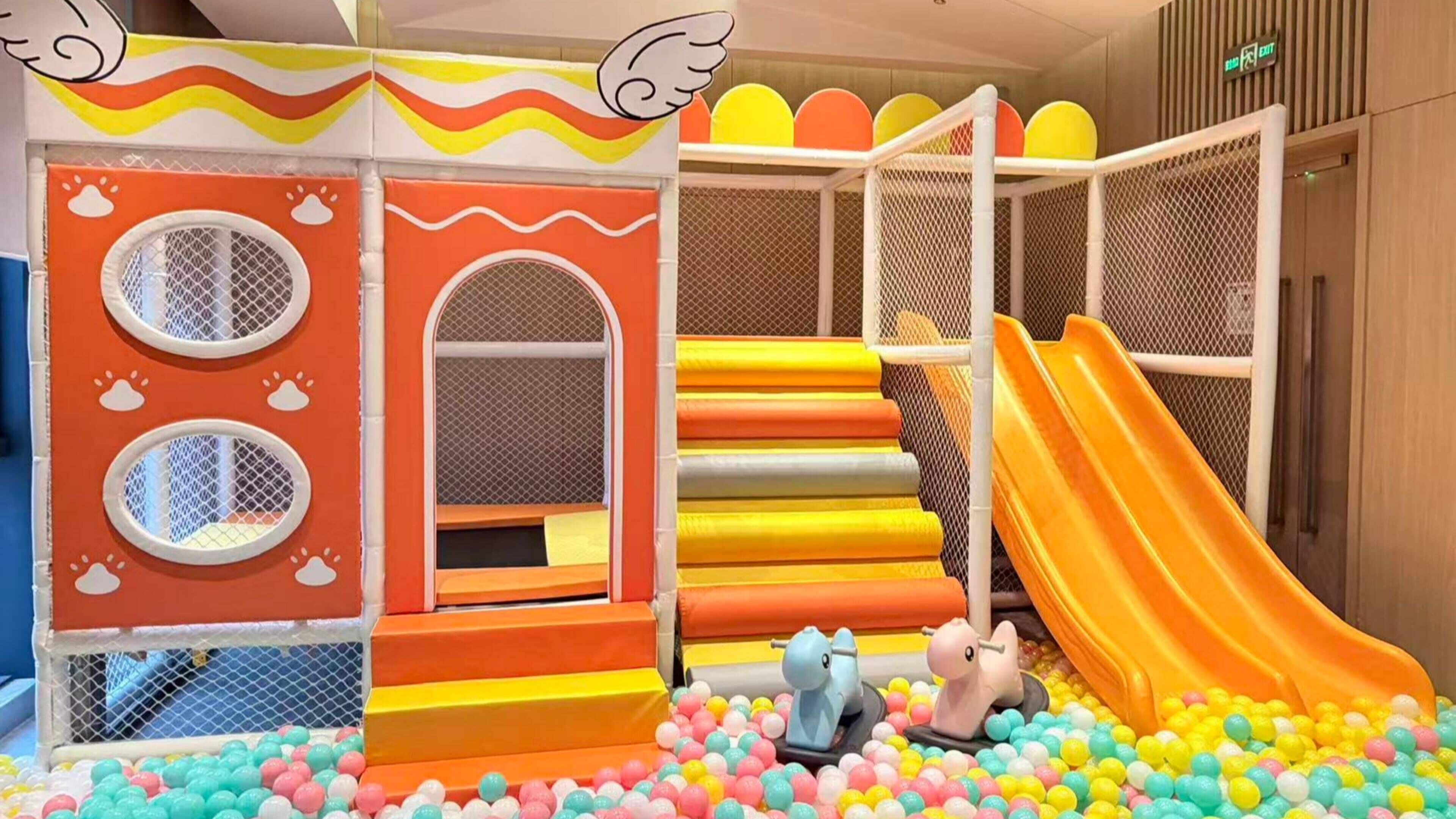 A children's play area with a slide, climbing steps, and a ball pit.