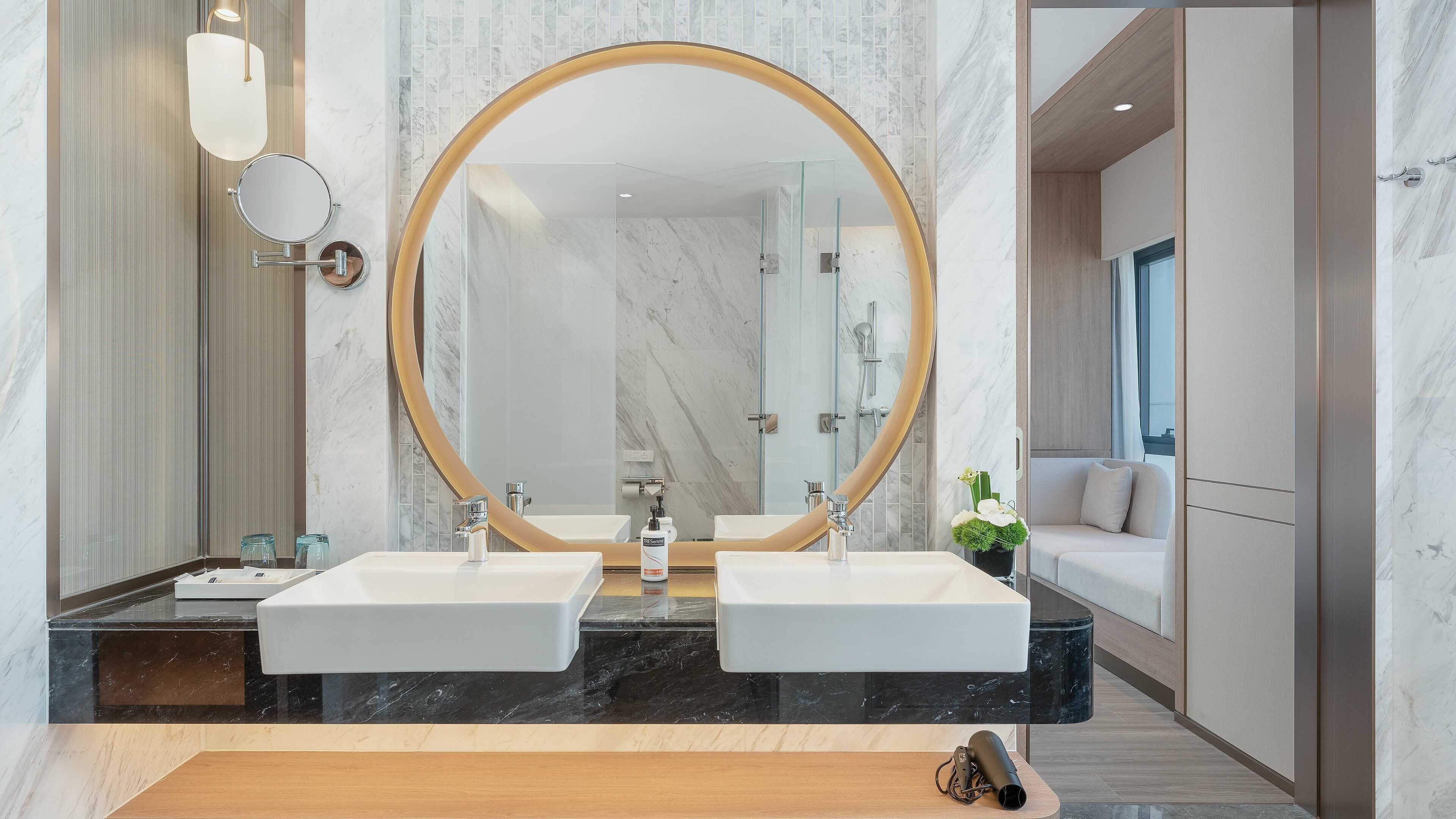 Une salle de bain moderne avec deux lavabos, un grand miroir et un espace douche.