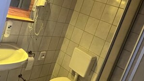 Ein modernes Badezimmer mit Toilette, Waschbecken und Dusche.