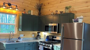A modern kitchen with a stainless steel refrigerator, a microwave, and a stove.