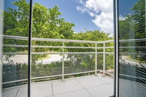 Enjoy a serene view of lush greenery from this balcony with a clear view.