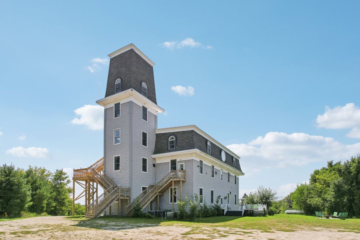 A large, multi-story building with a prominent tower and a staircase leading to the upper levels.