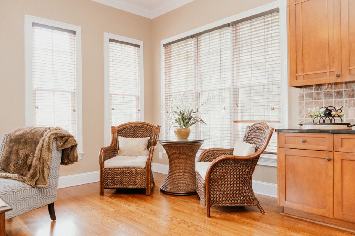 A cozy room with wicker furniture, a wooden cabinet, and a potted plant.