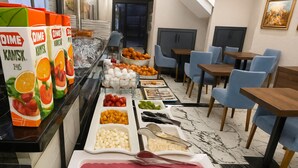 Una mesa de buffet con distintos alimentos y cartones de jugo.
