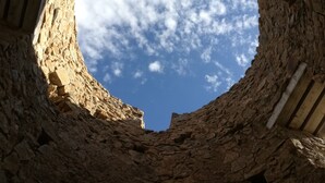 A circular stone window with a clear view of the sky and clouds. - Casa de Huéspedes Villa de las Hortensias (Bustarviejo)