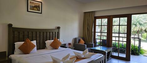 Habitación de hotel con una cama grande, un escritorio y vistas al exterior.