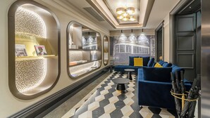 Ein modernes Interieur mit einem Schachbrettfußboden, einem blauen Sofa und einer Wand mit Rundfenstern.
