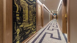 Ein Hotelgang mit einem gemusterten Boden, einer großen Wanddekoration und einer Tür mit der Nummer 509.
