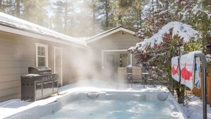 A hot tub in a backyard with a grill and a dining table. - Modern and Clean with a Spa! Close to Snow Summit. (Big Bear)