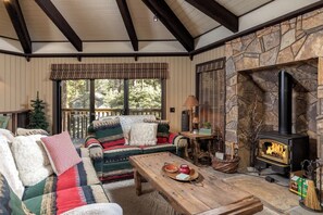 Una sala de estar acogedora con chimenea de piedra, una mesa de centro de madera y un sofá cómodo.