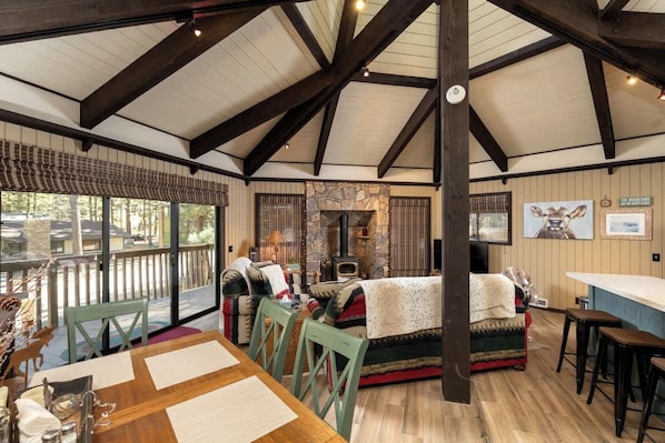 A cozy interior with a dining area, a fireplace, and a bar.