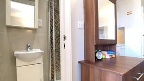 Ein Badezimmer mit Waschbecken, Spiegel und Holzschrank.