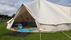 Ein Zelt aus Stoff mit Schlafbereich, kleinem Pool und Picknicktisch.