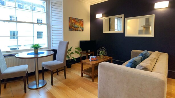 A modern living room with a sofa, chairs, a coffee table, and a TV. - S8 - Comfy Apartment in the heart of Hyde Park (London)