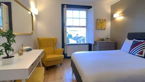 A bedroom with a bed, a desk, a chair, a potted plant, a dresser, and a window. - S8 - Comfy Apartment in the heart of Hyde Park (London)