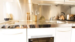 Una cocina moderna con electrodomésticos de acero inoxidable, horno empotrado y microondas.