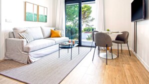 A modern living room with a sofa, coffee table, and dining area. - Genteel Home Arruzafa VIII (Cordoba)