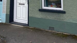 Une maison avec une porte blanche et une fenêtre.