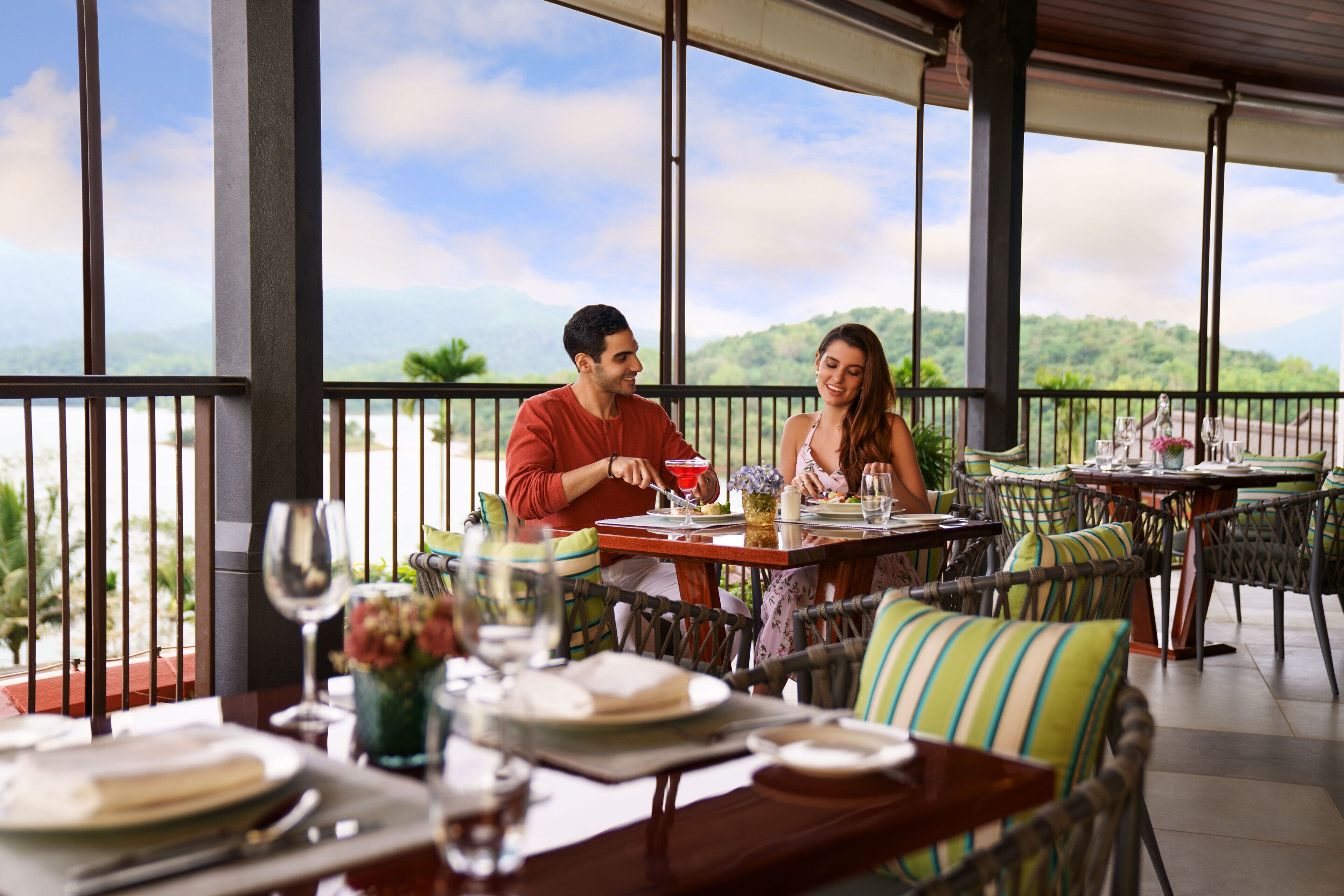 Un restaurant doté d’une terrasse, de grandes fenêtres et offrant une vue sur les montagnes.