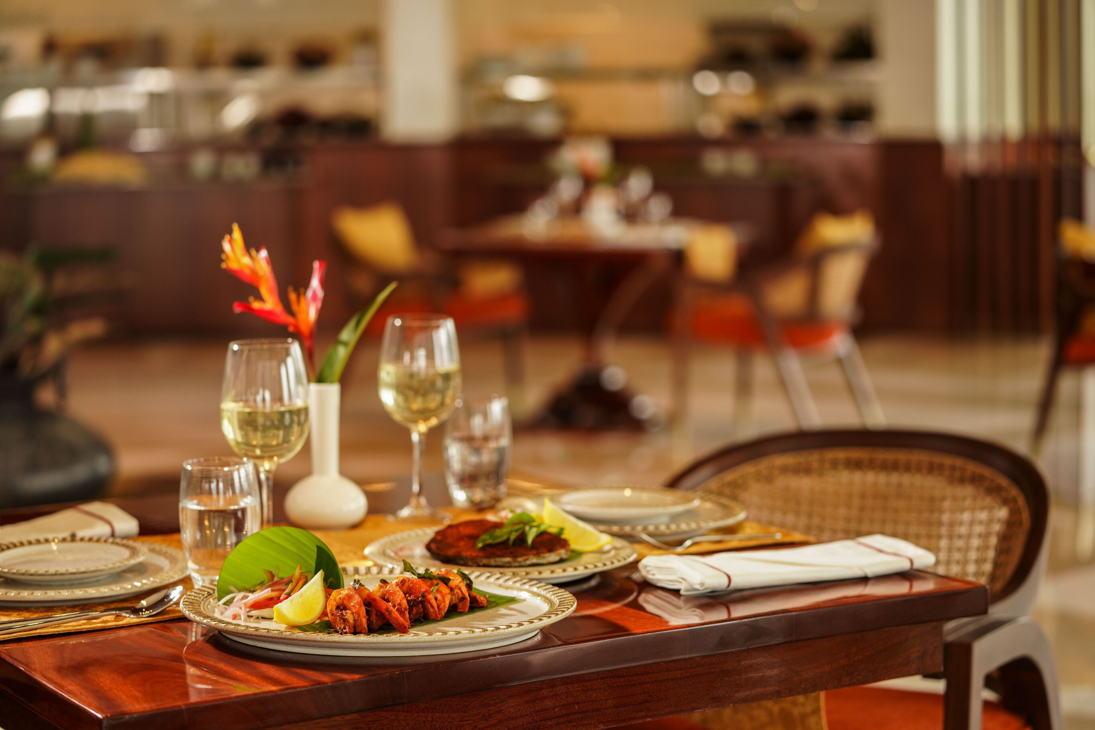 A dining table set with plates, glasses, and a decorative centerpiece.
