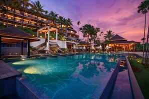 A resort with a large swimming pool, multiple balconies, and palm trees. - Taj Wayanad Resort & Spa, Kerala (Vythiri)